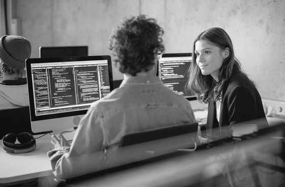 Estudantes de engenharia informática a trabalhar em programação numa sala de aula moderna.